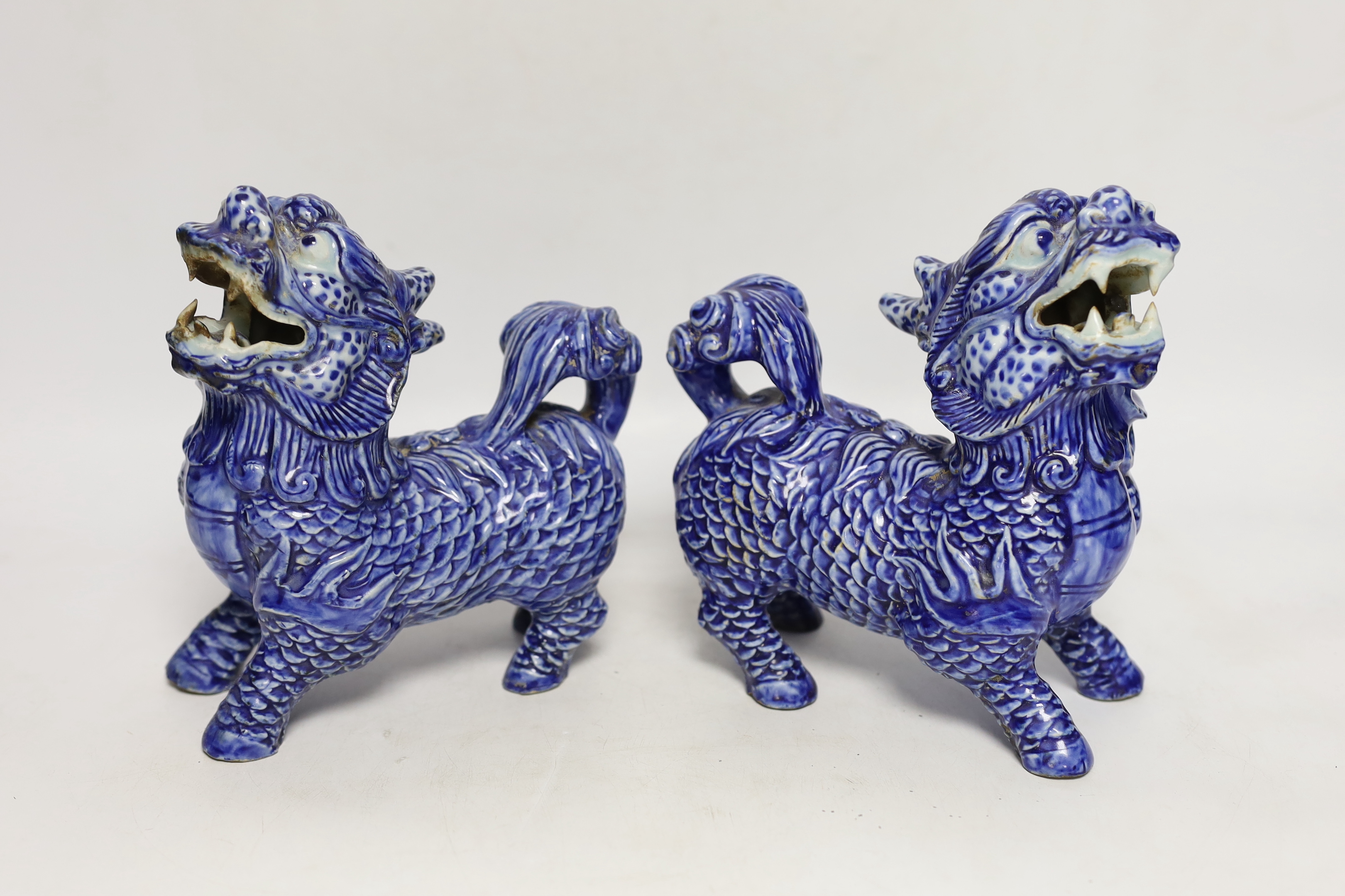 Two pairs of Chinese lion dogs; a blue and white porcelain set and a carved soapstone set, together with a carved jade lion, tallest 18cm (5)